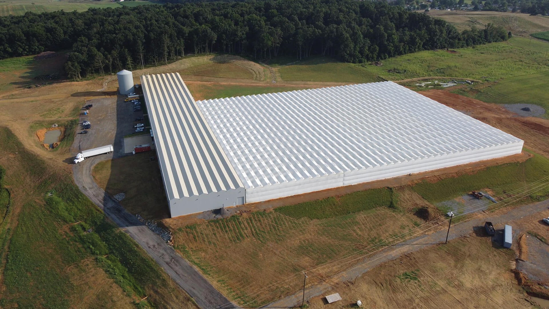 Overhead perspective of The Plant Company Greenhouse, featuring a spacious warehouse with a distinctive large roof